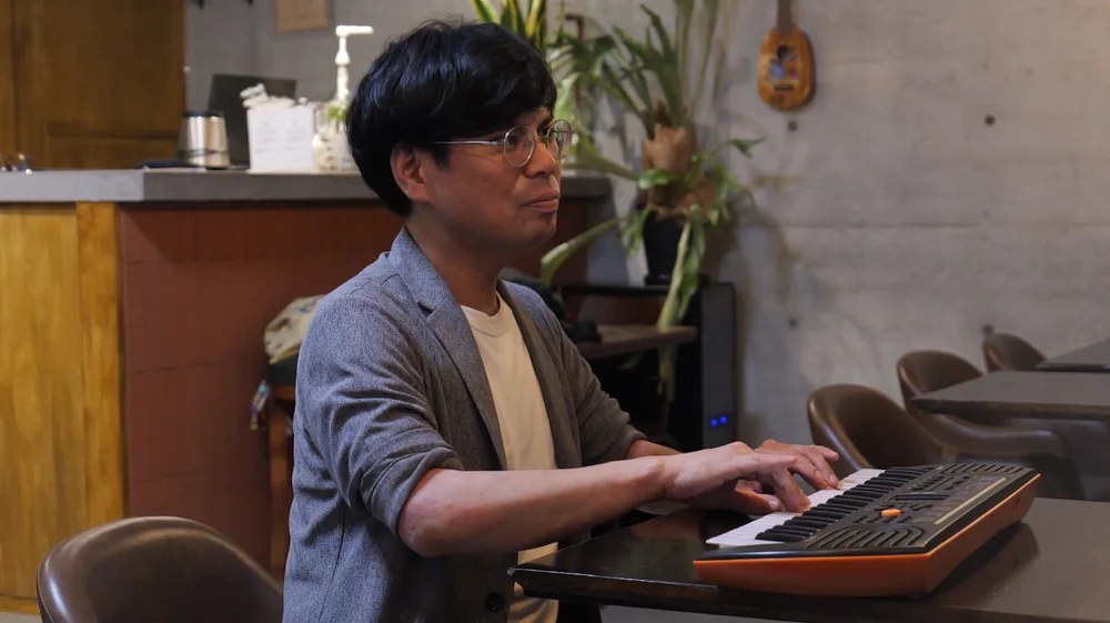 鍵盤を弾きながら声の出し方を実演する講師